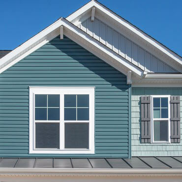 Three different finishes of fiber cement siding installed on one house